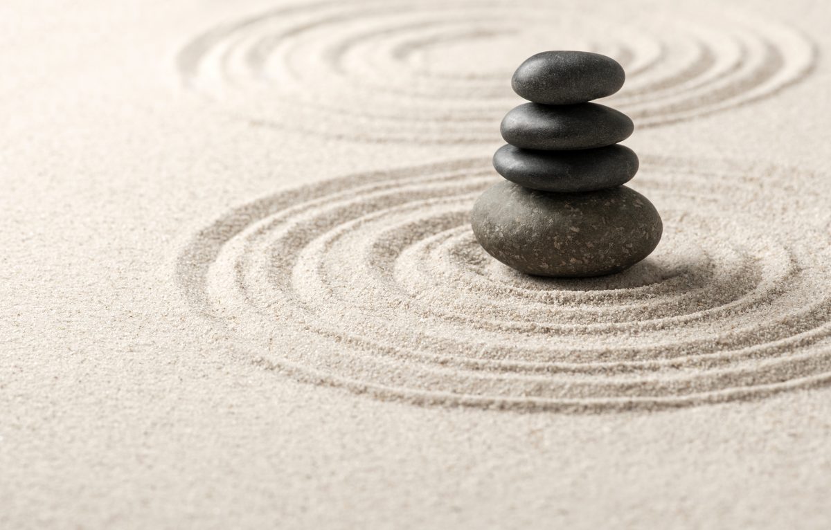 Stacked zen stones sand background art of balance concept ©