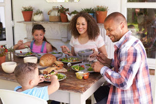 Family At Home Eating Outdoor Meal Together ©