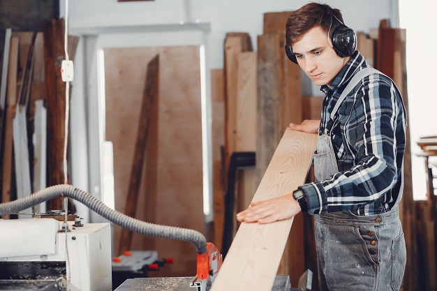 A man carves a tree. The carpenter works in a studio. An engineer provides a tree shape ©