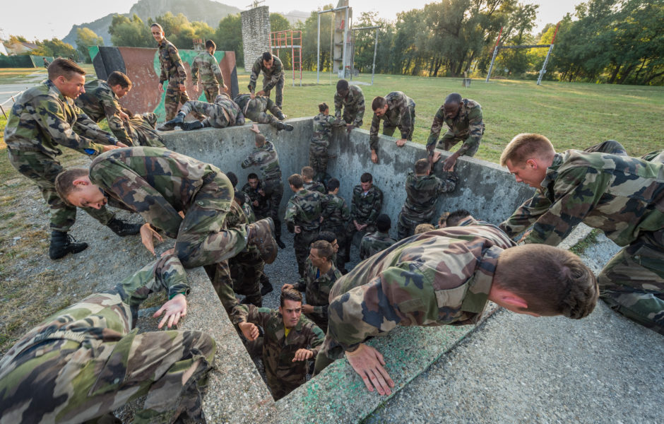 Les militaires de la section FGE du 93e RAM s'échauffent avant la séance d'entrainement de PO avec l'obstale n°17 (la fosse), sous la directive de la Maréchal des Logis Lariza (second plan à gauche).
 ©